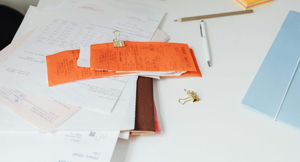 Close-up of a tidy desk with receipts, documents, and office stationery for business organization.