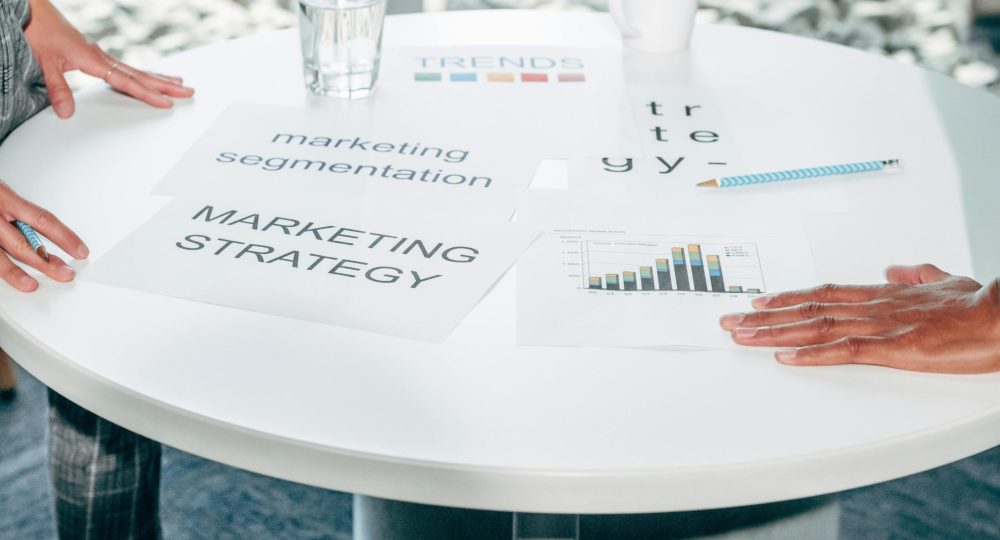 Two professionals collaborate on marketing strategy and segmentation at a round table.